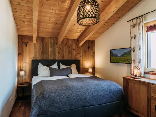 a bedroom with a bed in a room with wooden walls at Golden Geier in Rauris