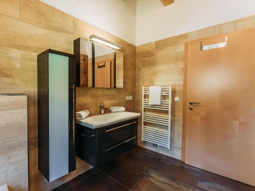ein Bad mit einem Waschbecken und einem Spiegel in der Unterkunft Golden Geier in Rauris
