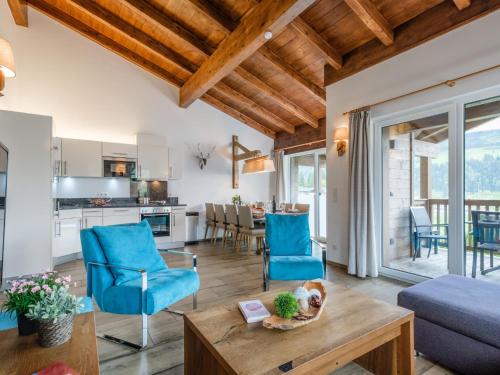 a living room with a table and blue chairs at BergbiberLODGE S in Piesendorf