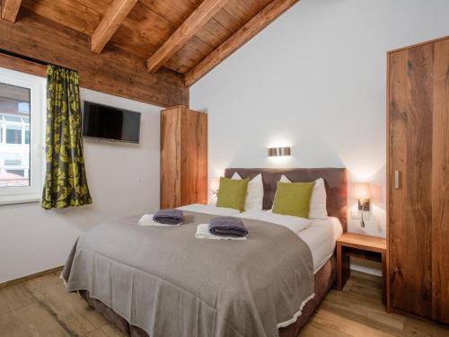 a bedroom with a large bed with green pillows at BergbiberLODGE S in Piesendorf