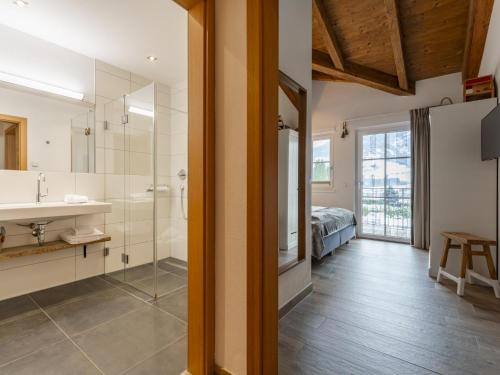 a bathroom with a sink and a shower and a bed at Luxury Tauern Suite Walchen-Kaprun 3 in Piesendorf