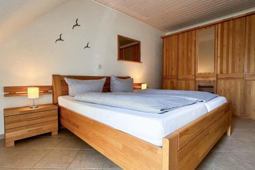 1 dormitorio con 1 cama grande de madera en una habitación en Ferienwohnung-10-mit-Balkon-Garten-Landhaus-Hubertus-Duhnen, en Cuxhaven