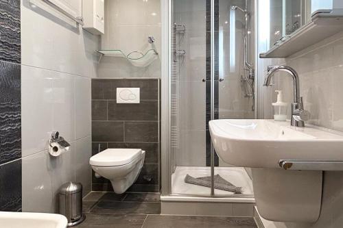 a bathroom with a toilet and a sink and a shower at Ferienwohnung-10-mit-Balkon-Garten-Landhaus-Hubertus-Duhnen in Cuxhaven