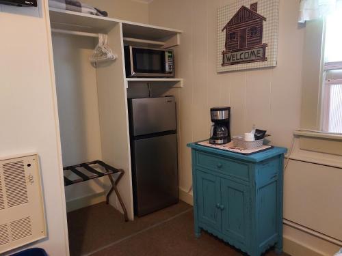 a kitchen with a blue cabinet and a refrigerator at Serenity Motel in Shaftsbury