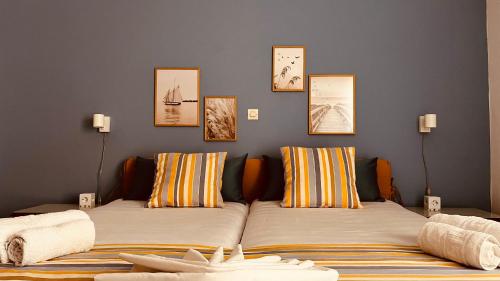 アギア・マリーナ・ネア・キドニアスにあるMichael Apartmentsの壁に絵が飾られた部屋のベッド2台