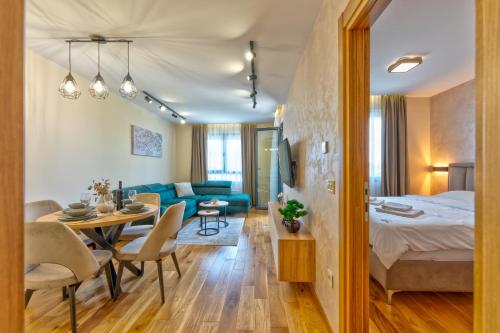 a hotel room with a bed and a dining room at Apartman Filipović, Vila Dunav in Zlatibor