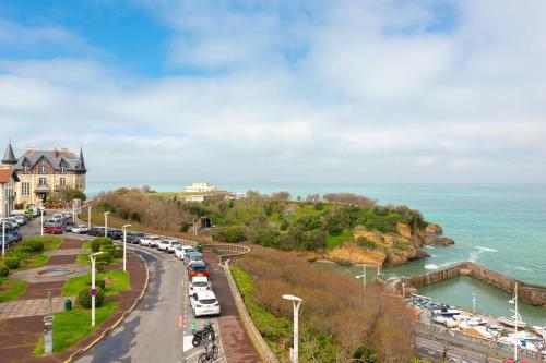 une rue animée avec des voitures garées au bord de l'eau dans l'établissement MOANA KEYWEEK Sea view apartment Biarritz downtown, à Biarritz