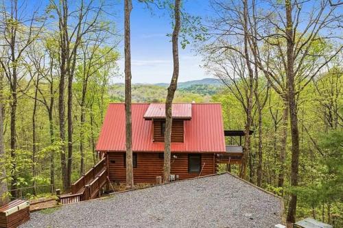 a cabin in the woods with a red roof at Charley Brown Cabin in Cherry Log