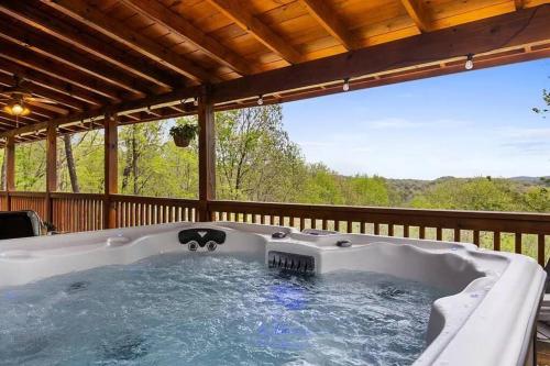 un jacuzzi en la terraza de una casa en Charley Brown Cabin, en Cherry Log