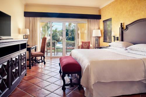 a hotel room with a bed and a balcony at The Club at Hacienda del Mar in Cabo San Lucas