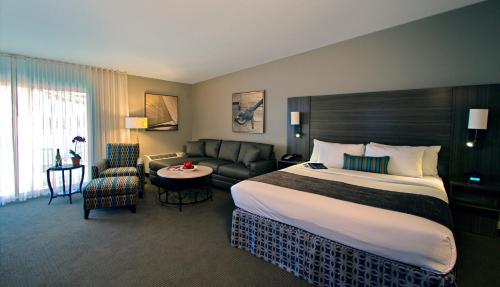 a hotel room with a large bed and a couch at Executive Inn & Suites Oakland in Oakland