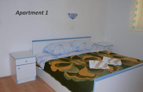 a bedroom with a bed with a flower comforter at Apartment Lopar 14804a in Lopar
