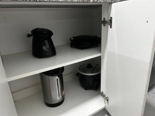 a kitchen shelf with a tea pot and a blender at Departamento familiar en el centro de Lima Perú in Lima