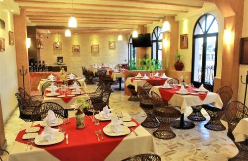 un ristorante con tavoli e sedie in una stanza di Hoteli Alifer Tlaxcala X TECAL LIVING a Tlaxcala de Xicohténcatl