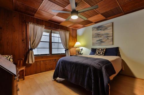 Un dormitorio con una cama y un ventilador de techo. en 2-2 Beachside Home With Private Pool, en New Smyrna Beach