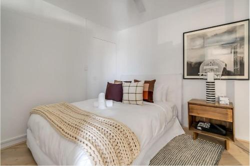 a bedroom with a bed and a table with a picture at Cosy Retreat in Bondi Junction -1BR Gem in Sydney