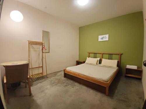 1 dormitorio con cama y escritorio. en The Cottage Stay formerly Sunset Homestay 2, en Kuching
