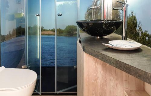 a bathroom with a sink and a glass shower at 1 Bedroom Beach Front Ship In Havelsee Ot Ktzkow 