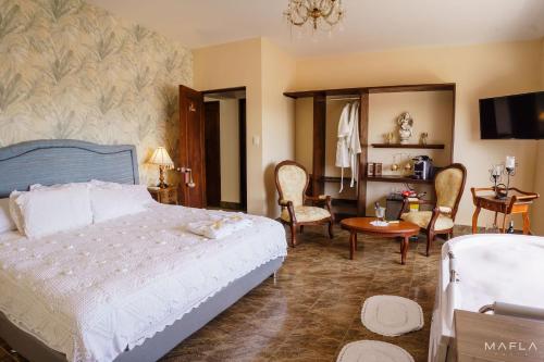 CASA LOMA HOTEL BOUTIQUE & TERRAZA GASTRO في بوبايان: غرفة نوم بسرير وطاولة وكراسي
