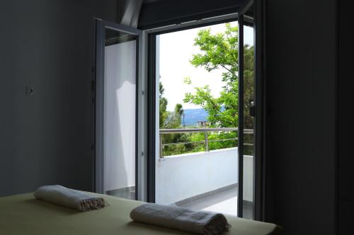 Habitación con una puerta de cristal que da a un balcón. en Νεόκτιστη βίλα, Χώρα Πυθαγορείου en Pythagóreion