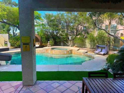 uma grande piscina num quintal com um banco em The Buddha Estate em Las Vegas