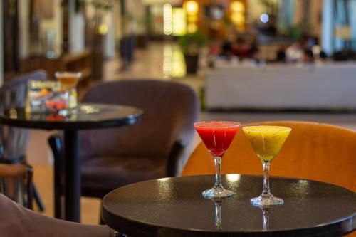 two cocktails sitting on a table in a restaurant at Hotel Guadalajara Plaza Expo in Guadalajara