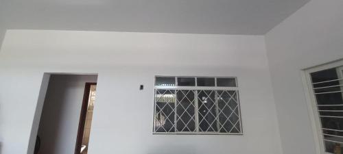 een deur met een raam in een witte muur bij Aluguel de quartos em residencia in Gurupi