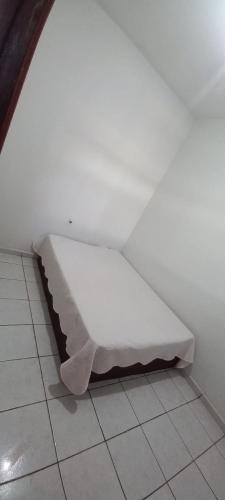 a white bench sitting on the floor of a room at Aluguel de quarto em residência in Gurupi