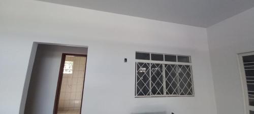 um quarto branco com uma porta e uma janela em Aluguel de quartos em residencia em Gurupi