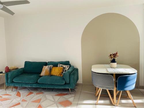 a living room with a green couch and a table at Bahia Garden -T2 Proche Université, Netflix, Fibre in Cayenne