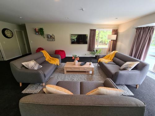 a living room with two couches and a coffee table at Rainforest Retreat in Franz Josef