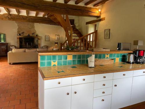 une cuisine avec un comptoir et un salon dans l'établissement Spacieuse maison au bord de la rivière, proche du Mans, avec équipements modernes, idéale pour familles - FR-1-410-440, à Solesmes