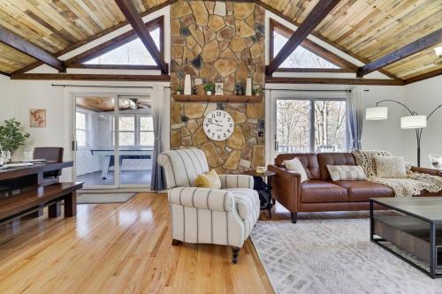 a living room with a couch and chairs and a stone wall at Pocono Mountains Luxury Retreat with king bed & game room in Cresco