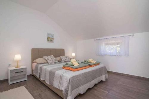 a bedroom with a bed with two pillows on it at Apartments with parking space Bonic, Losinj - 23056 in Veli Lošinj
