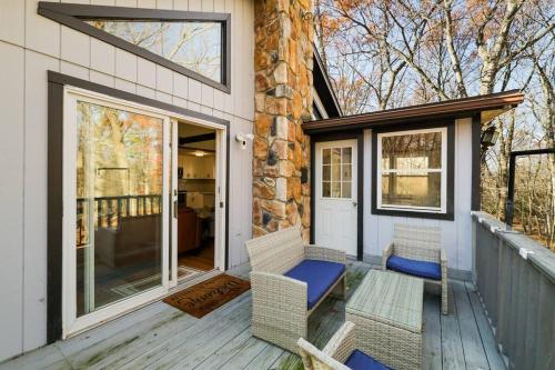 a porch with two chairs and a sliding glass door at Pocono Mountains Luxury Retreat with king bed & game room in Cresco