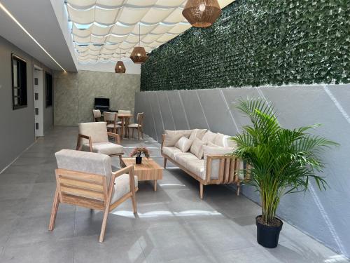 un vestíbulo con sofá, sillas y una planta en Colinas Del Bosque en Cuenca