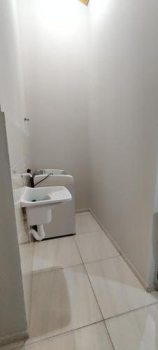 a white bathroom with a sink and a toilet at Apartamento modelo chalé 201 in Santo Ângelo