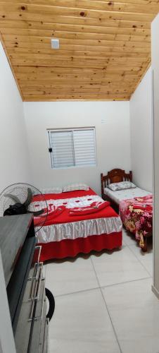 a bedroom with two beds and a wooden ceiling at Apartamento modelo chalé 201 in Santo Ângelo