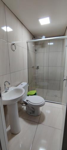 y baño con aseo, lavabo y ducha. en Apartamento modelo chalé 201, en Santo Ângelo