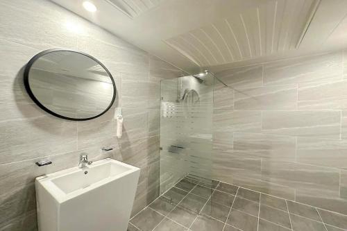 a white bathroom with a sink and a mirror at Mungyeong Stay 201 Hotel in Mungyeong
