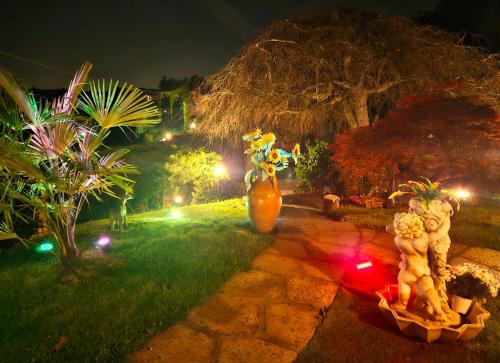 a garden at night with two vases and flowers at B&B Margot in Albavilla