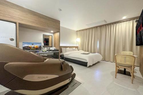 um quarto de hotel com uma cama e um sofá em Mungyeong Stay 201 Hotel em Mungyeong
