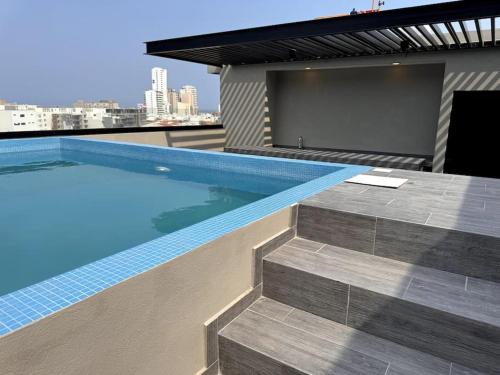 a swimming pool on top of a building with a television at Depa Luxe 2HAB con Alberca y Playa Caminando in Boca del Río