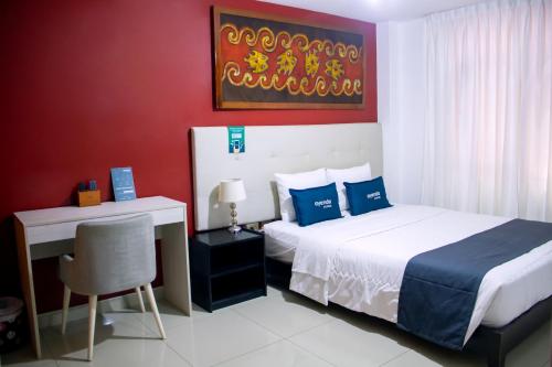 sypialnia z łóżkiem i biurkiem oraz łóżko o wymiarach 6 x 6 x 6 w obiekcie Hotel America Chiclayo w mieście Chiclayo