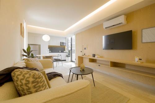a living room with a couch and a tv on a wall at Capitalia Aristoteles Polanco in Mexico City