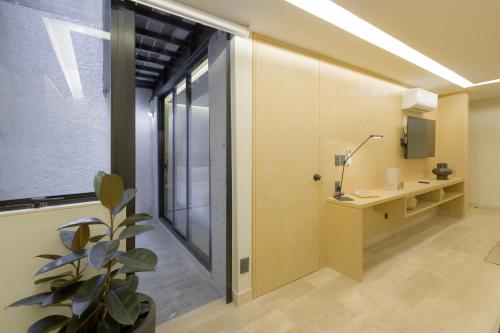 a room with a glass door with a desk and a plant at Capitalia Aristoteles Polanco in Mexico City
