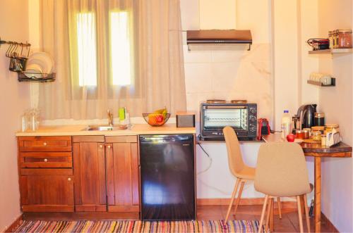 a kitchen with a counter and a microwave and a table at All Seasons Πέτρινες Παραδοσιακές Κατοικίες in Kalavrita
