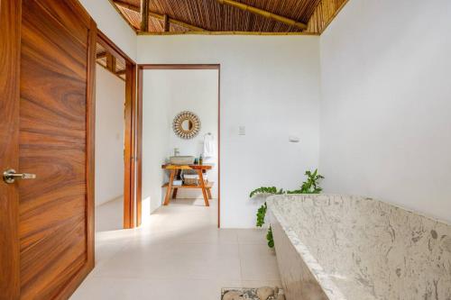 a hallway with a wooden door and a table at Villa Fruta del Cielo in Uvita