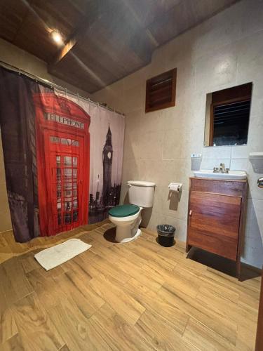 a bathroom with a toilet and a red door at Lura Bacalar in Bacalar