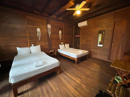 a bedroom with two beds and a ceiling fan at Lura Bacalar in Bacalar